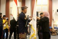 Ketua Umum DPP AWPI Hengki Ahmad Jazuli (kiri) menyerahkan bendera petaka AWPI yang diterima oleh ketua DPD AWPI Aceh Desi Anara Desky (kanan) Senin (6/2/2023)