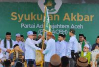 Teungku Haji Hasanoel Bashry (Abu Mudi) kiri menyerahkan bendera pataka Partai Adil Sejahtera (PAS) Aceh kepada Ketua Umum PAS Aceh Tu Bulqaini Tanjongan untuk dikibarkan hingga keseluruh pelosok Aceh untuk menegakkan amar ma'ruf nahi mungkar (foto : tim media PAS Aceh)