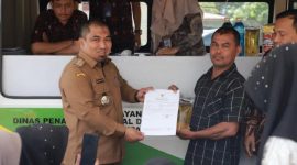 Pj Bupati Aceh Besar Muhammad Iswanto menyerahkan NIB kepada pelaku usaha yag mengurus izin usaha melalui mobil pelayanan perizinan keliling di halaman kantor Camat Blang Bintang, Kamis (7/9/2023).
