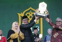 Pj Bupati Aceh Selatan, Cut Syazalisma didampingi istri menerima piala bergilir juara umum PKA-8 yang diserahkan oleh Penjabat Gubernur Aceh diwakili Sekda Bustami Hamzah pada penutupan PKA-8 di Panggung Utama Taman Ratu Safiatuddin, Banda Aceh, Minggu (12/112023). Sumber Foto ; MC PKA-8