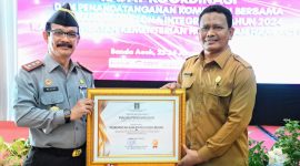Kepala Kantor Kemenkumham Wilayah Aceh Dr.Drs.Meurah Budiman menyerahkan penghargaan program prioritas nasional dibidang merk dan hak cipta kepada Pemerintah Kabupaten Aceh Besar yang diterima oleh Staf Ahli Bidang Perekonomian Pembangunan dan Keuangan Ir.Makmun, MT Selasa (23/1/2024) di Hotel Grand Nanggroe Banda Aceh