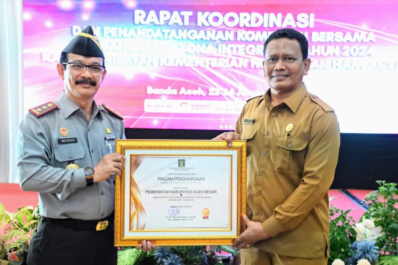 Kepala Kantor Kemenkumham Wilayah Aceh Dr.Drs.Meurah Budiman menyerahkan penghargaan program prioritas nasional dibidang merk dan hak cipta kepada Pemerintah Kabupaten Aceh Besar yang diterima oleh Staf Ahli Bidang Perekonomian Pembangunan dan Keuangan Ir.Makmun, MT Selasa (23/1/2024) di Hotel Grand Nanggroe Banda Aceh