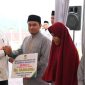 Pj Bupati Aceh Besar Muhammad Iswanto menyerahkan bonus kepada salah seorang juara MTQ Aceh Tahun 2023 di Simeulue pada momentum buka puasa bersama di Meuligoe Kota Jantho, Kamis, 21 Maret 2024.(Foto MC Aceh Besar)