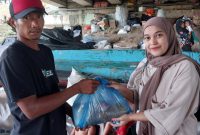 Salah seorang Pengurus HMI komisariat Tarbiyah dan keguruan UIN Ar Raniry Banda Aceh sedang menyerah paket kepada seorang warga yang kurang mampu hasil dari Kofatar Donasi Minggu (24/3/2024) di bawah jembatan lamnyong Darussalam Banda Aceh
