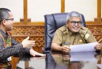 Pj Gubernur Aceh, Bustami Hamzah memperhatikan  laporan berbagai perkembangan dan pertumbuhan bisnis BSI di Aceh yang disampaikan Regional CEO BSI Aceh, Wisnu Sunandar pada pertemuan di Ruang Rapat Kantor Gubernur Aceh, Selasa, 19 Maret 2024. (Foto : Humas Pemerintah Aceh)