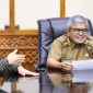 Pj Gubernur Aceh, Bustami Hamzah memperhatikan  laporan berbagai perkembangan dan pertumbuhan bisnis BSI di Aceh yang disampaikan Regional CEO BSI Aceh, Wisnu Sunandar pada pertemuan di Ruang Rapat Kantor Gubernur Aceh, Selasa, 19 Maret 2024. (Foto : Humas Pemerintah Aceh)