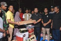 Pj Bupati Aceh Besar Muhammad Iswanto SSTP MM, menyerahkan bantuan masa panik kepada korban kebakaran lima rumah di Meunasah Manyang, Krueng Barona Jaya, Aceh Besar, Sabtu (20/4/2024) malam. Foto: MC Aceh Besar