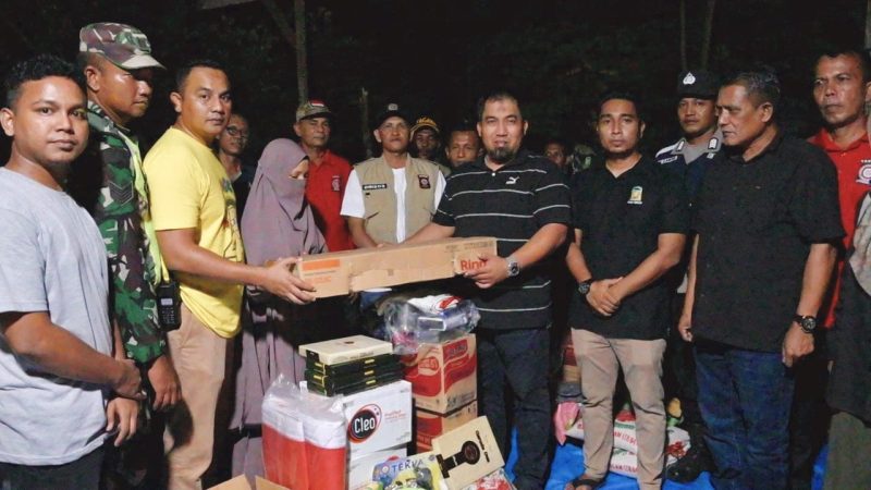 Pj Bupati Aceh Besar Muhammad Iswanto SSTP MM, menyerahkan bantuan masa panik kepada korban kebakaran lima rumah di Meunasah Manyang, Krueng Barona Jaya, Aceh Besar, Sabtu (20/4/2024) malam. Foto: MC Aceh Besar