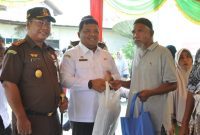 Sekda Aceh Besar Sulaimi bersama Kajari Basril G SH MH menyerahkan paket belanja kepada warga yang membeli di Pasar Murah Rabu (3/4/2024) Foto : MC Aceh Besar.