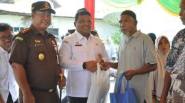 Sekda Aceh Besar Sulaimi bersama Kajari Basril G SH MH menyerahkan paket belanja kepada warga yang membeli di Pasar Murah Rabu (3/4/2024) Foto : MC Aceh Besar.