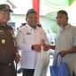 Sekda Aceh Besar Sulaimi bersama Kajari Basril G SH MH menyerahkan paket belanja kepada warga yang membeli di Pasar Murah Rabu (3/4/2024) Foto : MC Aceh Besar.