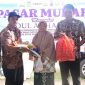 Kasi analis perdagangan Diskopukmdag Aceh Besar Abdul Hadi, SE menyerahkan paket secara simbolis paket pasar khusus kepada salah satu pembeli di Pasar Krueng Raya, Kecamatan Mesjid Raya, Aceh Besar, Kamis (6/6/2024) Foto : MC Aceh Besar