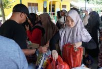 Petugas Dinas Pangan Aceh Besar dan Bulog Aceh melayani warga Lon Asan Kecamatan Lembah Seulawah, belanja pangan murah di Meunasah gampong setempat, Rabu (12/6/2024) FOTO : MC Aceh Besar