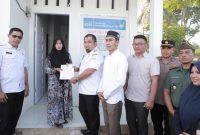 Pj Bupati Aceh Besar Muhammad Iswanto menyerahkan sertifikat rumah kepada Muhaimi Fahmi salah seorang penerima bantuan rumah dari Islamic Relief Indonesia dan Baitul Mal Aceh Besar di Gampong Lamteh Kecamatan Peukan Badan, Aceh Besar, Rabu (26/6/2024). Foto : MC Aceh Besar