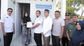 Pj Bupati Aceh Besar Muhammad Iswanto menyerahkan sertifikat rumah kepada Muhaimi Fahmi salah seorang penerima bantuan rumah dari Islamic Relief Indonesia dan Baitul Mal Aceh Besar di Gampong Lamteh Kecamatan Peukan Badan, Aceh Besar, Rabu (26/6/2024). Foto : MC Aceh Besar
