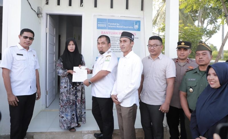 Pj Bupati Aceh Besar Muhammad Iswanto menyerahkan sertifikat rumah kepada Muhaimi Fahmi salah seorang penerima bantuan rumah dari Islamic Relief Indonesia dan Baitul Mal Aceh Besar di Gampong Lamteh Kecamatan Peukan Badan, Aceh Besar, Rabu (26/6/2024). Foto : MC Aceh Besar