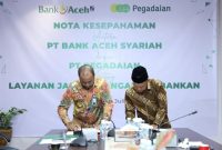 Plt Dirut Bank Aceh, Fadhil Ilyas dan Chief of Transformation Office PT Pegadaian, Mulyono menandatangani MoU penguatan kerja sama dan sinergi dalam upaya ekspansi dan meningkatkan layanan digital di Bank Aceh Kantor Pusat Banda Aceh, Rabu (17/7/2024). Foto : Humas Bank Aceh