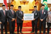 Plt Dirut Bank Aceh, Fadhil Ilyas menyerahkan deviden secara simbolis kepada Penjabat Gubernur Aceh, Bustami di Pendopo Gubernur Aceh, 22 Juli 2024. (Foto Humas Bank Aceh)