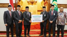 Plt Dirut Bank Aceh, Fadhil Ilyas menyerahkan deviden secara simbolis kepada Penjabat Gubernur Aceh, Bustami di Pendopo Gubernur Aceh, 22 Juli 2024. (Foto Humas Bank Aceh)