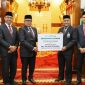Plt Dirut Bank Aceh, Fadhil Ilyas menyerahkan deviden secara simbolis kepada Penjabat Gubernur Aceh, Bustami di Pendopo Gubernur Aceh, 22 Juli 2024. (Foto Humas Bank Aceh)