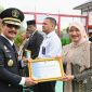 Pj Ketua Dewan Kerajinan Nasional Daerah Aceh Besar Cut Rezky Handayani, MM menerima Piagam Penghargaan Bidang Kekayaan Intelektual dari Kakanwil Kemenkumham Aceh, Dr. Drs. Meurah Budiman, S.H., M.H di Lapas Kelas II A, Gampong Bineh Blang, Kecamatan Ingin Jaya, Aceh Besar, Senin (19/8/202), Foto : MC Aceh Besar