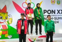 Ketua Pengprov PASI Bachtiar (kiri) melakukan foto bersama atlet peraih medali emas Lompat Tinggi Putri, usai  pengkalungan medali (Foto: Ist)
