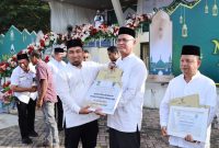 Pj Bupati Aceh Besar Muhammad Iswanto, S.STP, MM menyerahkan penghargaan atas perolehan juara lomba pengelolaan masjid se Aceh Besar kepada pengurus masjid Babussalam Kecamatan Krueng Barona Jaya Senin (9/12/2024).