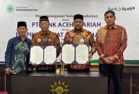 Pimpinan Pusat Muhammadiyah Agung Danarto dan Plt, Direktur Utama Bank Aceh Fadhil Ilyas memperlihatkan dokumen penandatanganan MoU Bank Aceh dan Muhammadiyah (Foto:Dok Ist)
