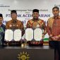 Pimpinan Pusat Muhammadiyah Agung Danarto dan Plt, Direktur Utama Bank Aceh Fadhil Ilyas memperlihatkan dokumen penandatanganan MoU Bank Aceh dan Muhammadiyah (Foto:Dok Ist)