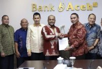 Penyerahan Laporan Hasil Audir Kantor Akuntan Publik yang diserahkan langsung oleh Padri Achyarsyah Signing Partner KAP Heliantono & Rekan dan diterima oleh Plt. Dirut Bank Aceh, Fadhil Ilyas.