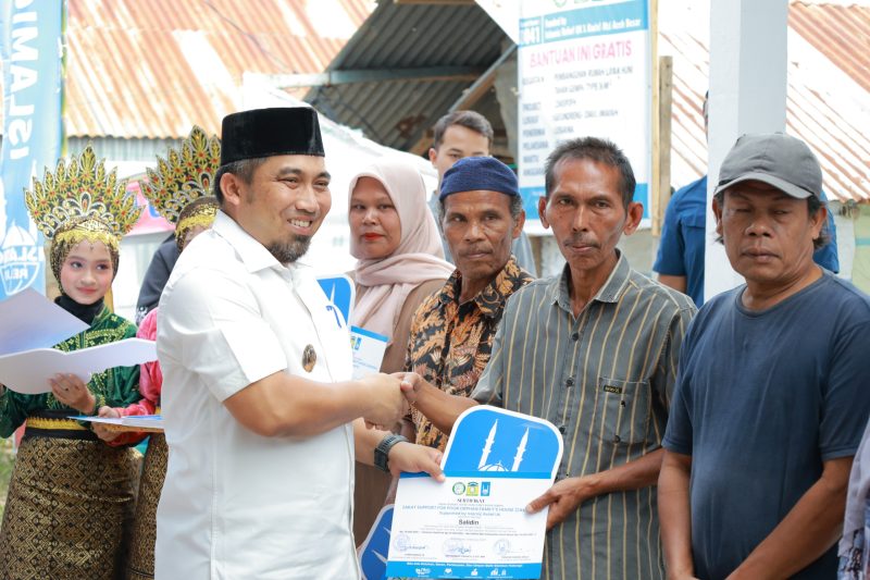 Pj Bupati Aceh Besar Muhammad Iswanto, S.STP, MM menyerahkan kunci rumah dhuafa berstruktur tahan gempa tipe 36 secara simbolis kepada penerima manfaat di Gampong Geundrieng Kecamatan Darul Imarah Aceh Besar  Minggu (2/2/2025) Foto : MC Aceh Besar