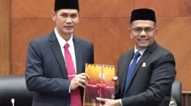 Plt Sekda Aceh, M Nasir menyerahkan Rancangan Qanun Aceh tentang RPJM Aceh Tahun 2025-2030 kepada Wakil DPR Aceh, Saifuddin. Rabu (30/7/2025) di ruang utama DPR Aceh  Foto: Ist