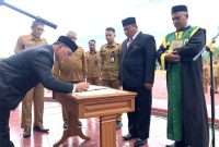Bupati Aceh Besar, Muharram Idris menandatangani berita acara pelantikan dan mengangkat sumpah Bahrul Jamil sebagai Sekda Aceh Besar di Lapangan Upacara Kantor Bupati Aceh Besar di Kota Jantho, Senin, (14/7/2025). Foto : Portalnusa.com