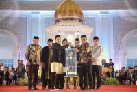 Bupati Aceh Besar H Muharram Idris (Syech Muharram) menerima piala bergilir juara umum MTQ ke-37 Aceh tahun 2025 yang diserahkan oleh Wakil Gubernur Aceh Fadhlullah SE, pada malam penutupan di Arena Utama Komplek Perkantoran Pemkab Pidie Jaya Jumat malam (7/11/2025), Foto : Prokopim Aceh Besar