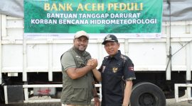 Direktur Utama Bank Aceh Syariah Fadhil Ilyas melakukan salam komando dengan Bupati Pidie Jaya Tgk H Syibral Malasyi, MA usai menyalurkan bantuan tanggap darurat kepada korban banjir di Kabupaten Pidie Jaya, Sabtu (13/12/2025). Foto Humas Bank Aceh Syariah