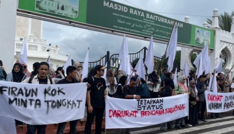 Ratusan warga yang tergabung dalam Koalisi Masyarakat Sipil Aceh Peduli Bencana Sumatera menggelar aksi unjuk rasa di depan Masjid Raya Baiturrahman, Banda Aceh, Kamis (18/12/2025).