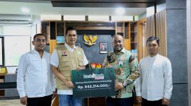 Direktur Utama Bank Aceh Fadhil Ilyas menyerahkan bantuan secara simbolis yang diterima oleh Sekda Aceh Muhammad Nasir, S.IP, MPA disela rapat Koordinasi Penyusunan Dokumen Rencana Rehabilitasi dan Rekontruksi Pasca bencana Provinsi Aceh di kantor Gubernur Aceh Jumat (2/1/2026).