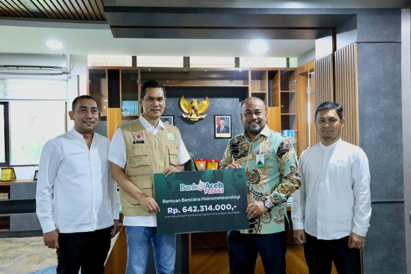 Direktur Utama Bank Aceh Fadhil Ilyas menyerahkan bantuan secara simbolis yang diterima oleh Sekda Aceh Muhammad Nasir, S.IP, MPA disela rapat Koordinasi Penyusunan Dokumen Rencana Rehabilitasi dan Rekontruksi Pasca bencana Provinsi Aceh di kantor Gubernur Aceh Jumat (2/1/2026).