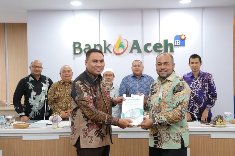 Kantor Akuntan Publik (KAP) Heliantono & Rekan menyerahkan dokumen hasil audit laporan keuangan tahun buku 2025 kepada Dirut Bank Aceh, Fadhil Ilyas sebagai bentuk pengakuan atas kepatuhan bank terhadap standar pelaporan keuangan yang berlaku di Gedung Action Center Banda Aceh, Jumat, (13/1/2026). Foto : Humas Bank Aceh