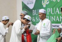 Ketua Umum Partai PAS Aceh Tgk.H.Tu Bulqaini Tanjongan memberikan santunan anak yatim pada acara buka puasa bersama di Sekretariat MPP PAS Aceh di kawasan Lhueng Bata Banda Aceh, Sabtu (14/3/2026).Foto : Humas PAS Aceh