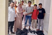 Kepala Sekolah SMAN 15 Adidarma Banda Aceh Dr. Salma Hanum, S.Pd, M.Pd didampingi oleh komite sekolah Dr. Kismullah dan guru lainnya, saat memberikan daging kurban kepada siswa sekolah setempat, Jumat (29/5/2026).