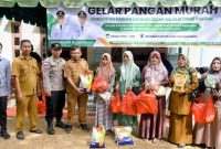 Kadis Pangan Aceh Besar, Alyadi S.Pi, MM menyerahkan secara simbolis paket belanja pada pangan murah yang digelar oleh Pemkab Aceh Besar melalui Dinas Pangan di Halaman Kantor Camat Sukamakmur, Sibreh, Aceh Besar, Senin (12/05/2026). Foto : MC Aceh Besar
