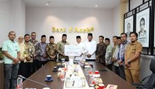 SERAHKAN ZAKAT - Direktur Utama (Dirut) Bank Aceh Syariah, Fadhil Ilyas (7 kiri), secara simbolis menyalurkan zakat melalui Kepala Baitul Mal Aceh, Tgk HM Yunus M Yusuf, di kantor pusat bank tersebut, Selasa (1/9/2026). Dok Humas Bank Aceh