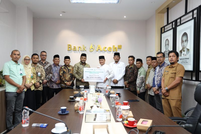 SERAHKAN ZAKAT - Direktur Utama (Dirut) Bank Aceh Syariah, Fadhil Ilyas (7 kiri), secara simbolis menyalurkan zakat melalui Kepala Baitul Mal Aceh, Tgk HM Yunus M Yusuf, di kantor pusat bank tersebut, Selasa (1/9/2026). Dok Humas Bank Aceh