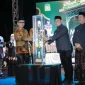 Bupati Aceh Besar H. Muharram Idris menyerahkan piala bergilir kepada Camat Peukan Bada, Salamuddin ZM, SE usai menjadi Juara Umum MTQ ke-35, Jumat (30/10/2026) malam.
